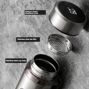 Stainless steel thermos with digital temperature display on a gray surface