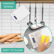 Kitchen utensils hanging on a rack with a digital scale and rolling pins on a tiled wall.