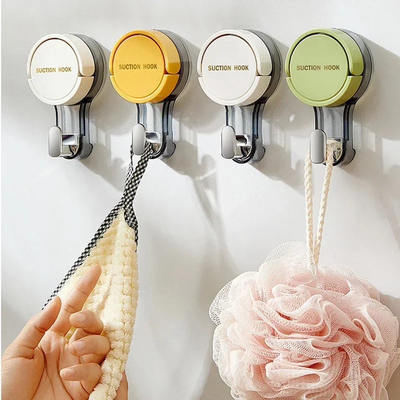 Four suction hooks on a white wall with bath products hanging from them.