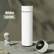 White 500ML thermos bottle with digital temperature display on a gray surface.