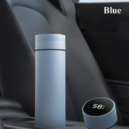 Blue thermos bottle with digital temperature display on a car dashboard