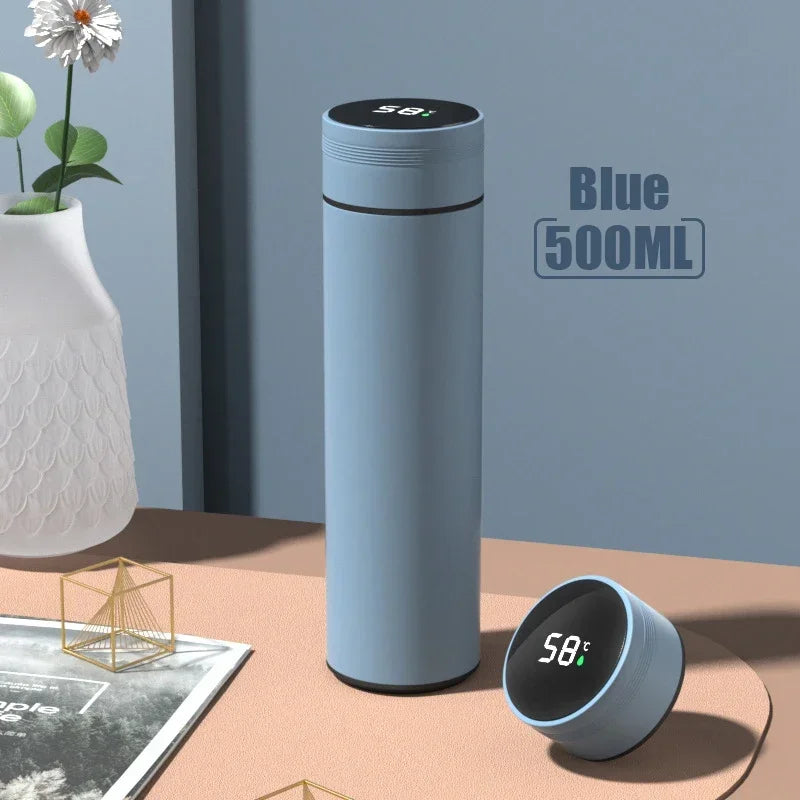 Blue thermos bottle with digital display on a table with a vase and plant in the background