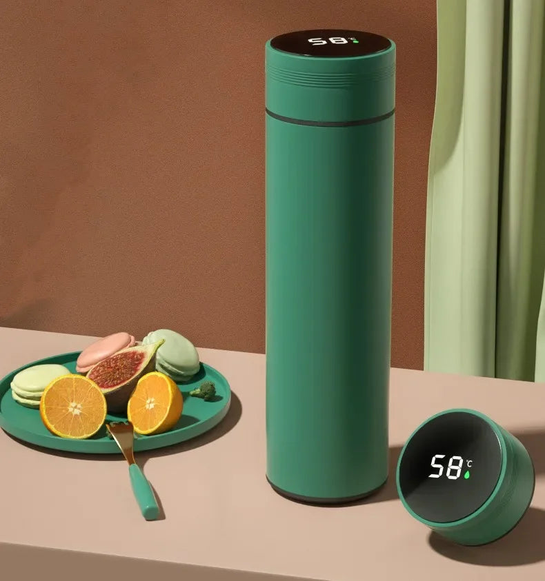 Green thermos bottle with digital display on a table with fruits and cookies