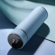 White thermos with digital temperature display on a reflective surface